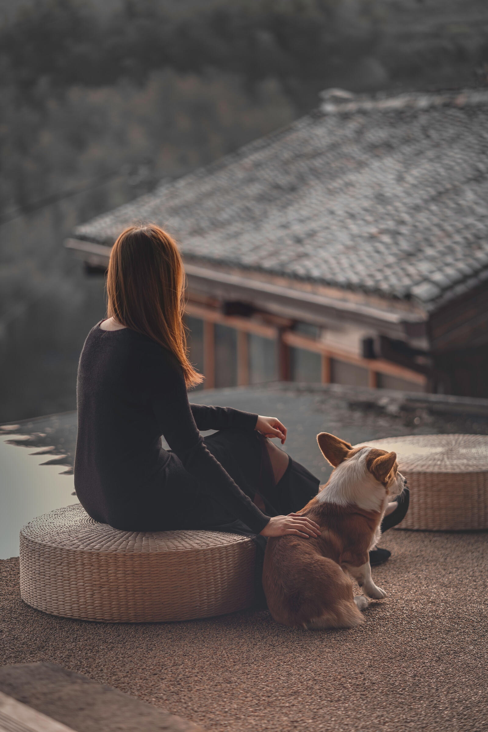 Woman sitting outdoors with her dog beside her